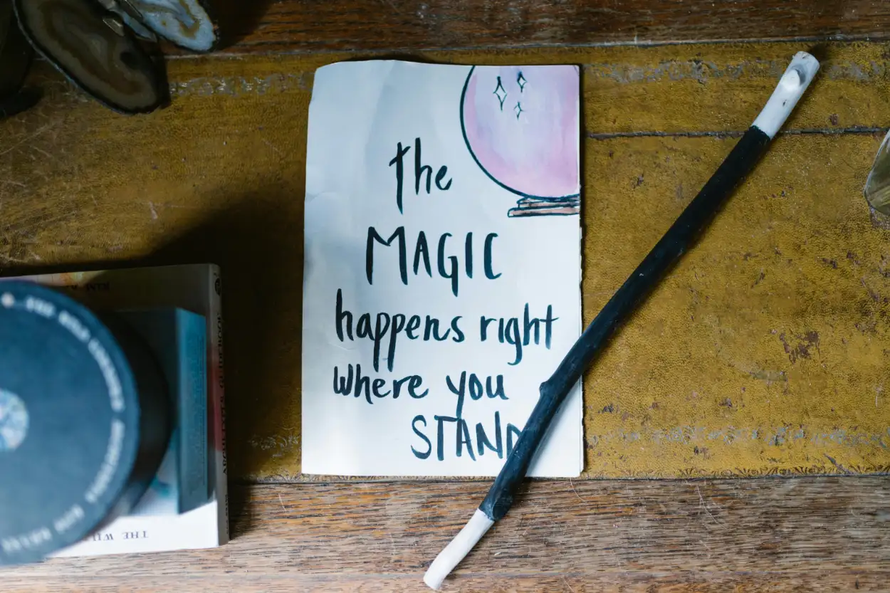 Handwritten note on a piece of paper beside a magic wand on a table, symbolising the power of the reticular activating system to bring focus and intention to life.